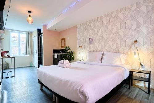 a bedroom with a large white bed with a stuffed animal on it at NG Prestige - Lille I Roubaix Centre I Grande Rue - Studio - Netflix & Wifi in Roubaix