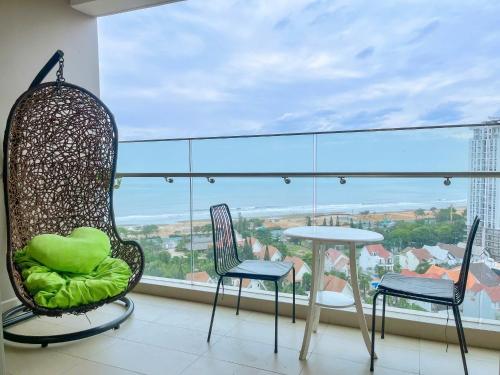 d'un balcon avec des chaises, une table et une grande fenêtre. dans l'établissement The Sóng Tourist Apartment Tam Thắng Vũng Tàu, à Vung Tau