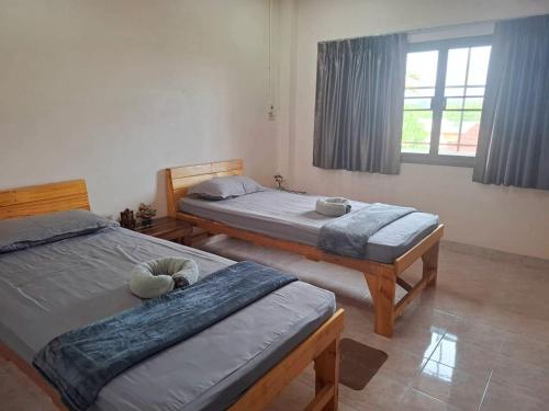 a bedroom with two beds and a window at Padang Besar Border Private room & Hostel in Sathani Padang Besa