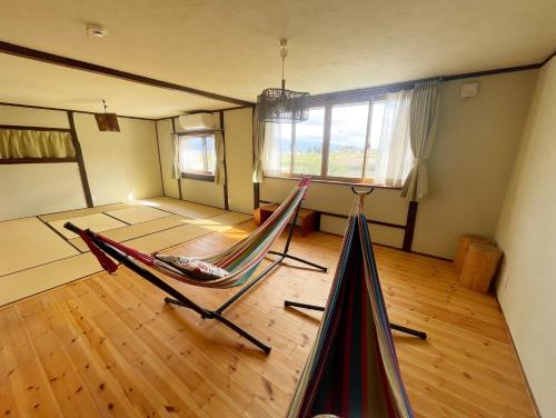 a room with a hammock in the middle of it at 安曇野ふくろうハウス The OWL Villa mountain view in Hotaka