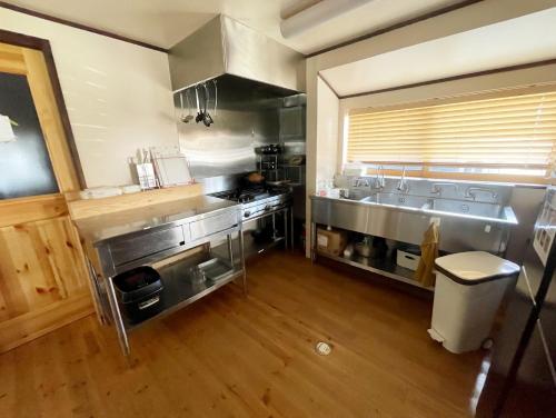 a large kitchen with stainless steel appliances and wooden floors at 安曇野ふくろうハウス The OWL Villa mountain view in Hotaka