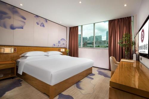 深セン市にあるMotri莫里宝乐城市酒店の白いベッドと大きな窓のある寝室
