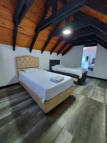 een slaapkamer met 2 bedden in een kamer met houten plafonds bij Casa Bella in Rivera
