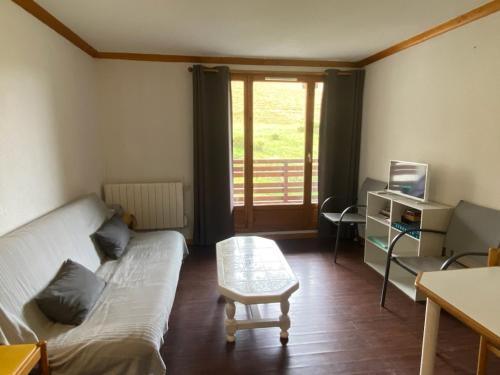 un salon avec un canapé et une table dans l'établissement Appartement cosy 4 pers. – Balcon, parking - FR-1-814-166, à Chastreix