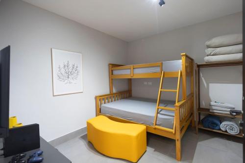 a bedroom with a bunk bed and a yellow stool at 113-Studio Amplo e completo com ar condicionado prox UEL in Londrina