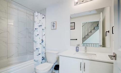 a bathroom with a toilet and a sink and a shower at Downsview Park Luxury Townhome near Yorkdale Transit in Toronto