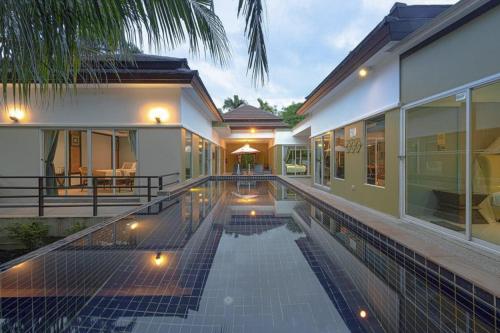 a house with a swimming pool next to a building at De palm poolvilla by KC in Ban Chin Tham Mai