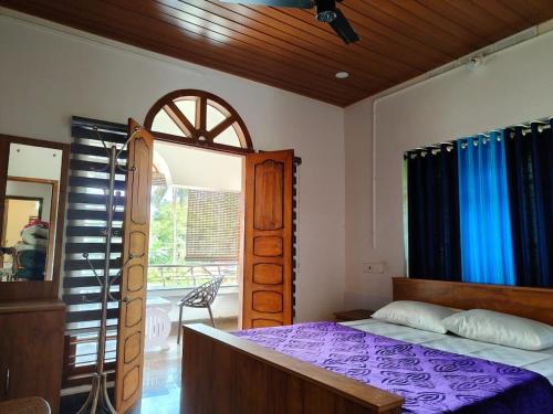 a bedroom with a bed and a large window at whisperingstrem's RIVER view homestay in Padinjarathara
