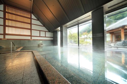 a room with a pool in a building with windows at Shoho in Matsumoto