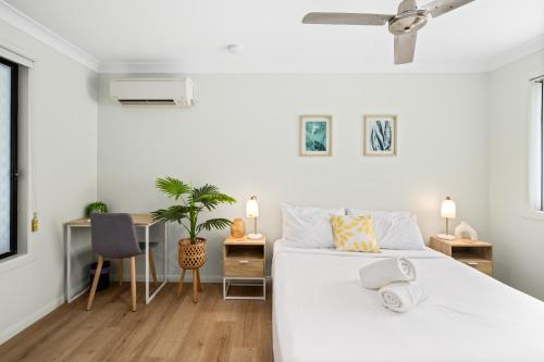 a white bedroom with a bed and a desk at Smart Suites Self Check-in Apartments - Sunnybank Station in Brisbane