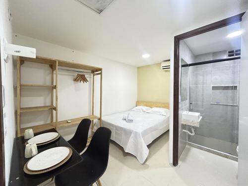 Schlafzimmer mit einem Bett und einer Glasdusche in der Unterkunft Flat funcional mobiliado com cozinha e WC privativo apt103 in Recife