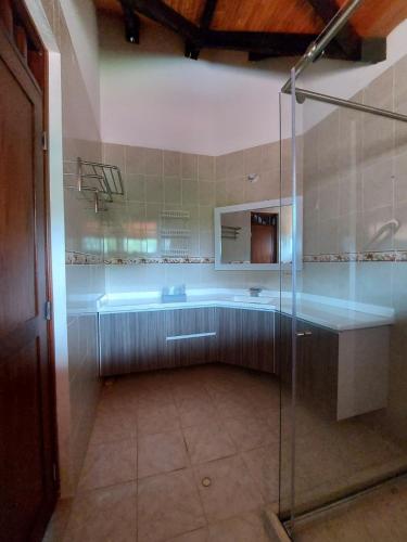 een badkamer met een glazen douche en een wastafel bij Casa Bella in Rivera