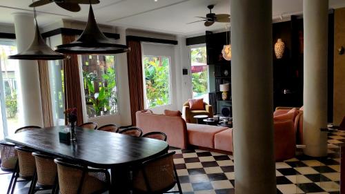 un salon avec une table et un canapé dans l'établissement Helene's House Ubud - Christmas and New Year in 5BR Private Pool Villa, à Ubud