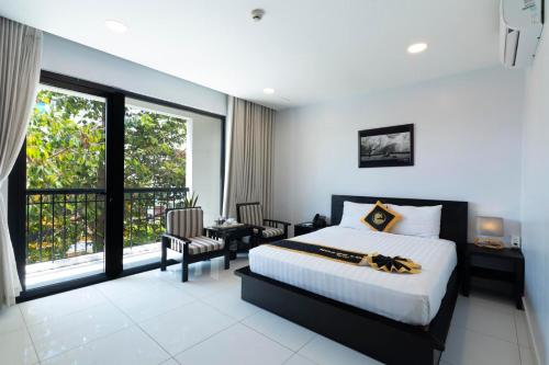 Un dormitorio con una cama y una ventana grande en Hoang Long Hotel Phan Thiết, en Phan Thiet