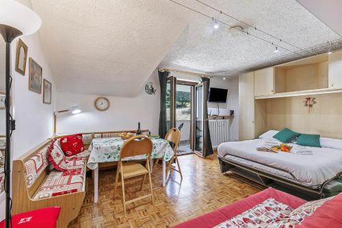 a room with a bed and a table and a couch at Appartamento La Selva Incantata - Happy Rentals in Sauze d'Oulx