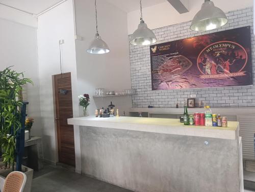 a kitchen with a counter and a poster on the wall at Mt Olympus Retreat Hotel in Mae Nam