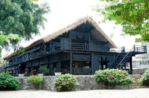 a building with a thatch roof with a restaurant at Golden Hotel in Buon Ma Thuot