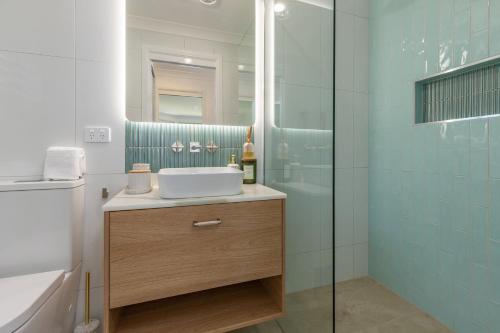 a bathroom with a sink and a glass shower at Luminara Luxury Lakefront in Smiths Lake