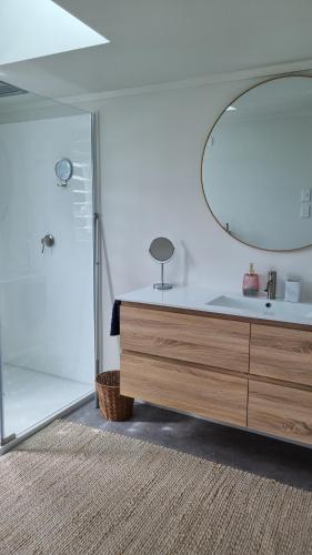 ein Badezimmer mit Waschbecken und Spiegel in der Unterkunft Beach Break in Ahipara