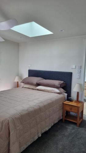 ein Schlafzimmer mit einem großen Bett mit blauem Kopfteil in der Unterkunft Beach Break in Ahipara