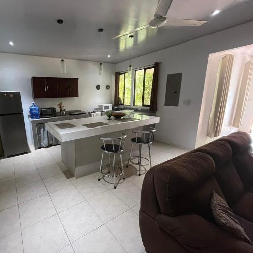 a kitchen with a counter and a couch in a room at Casa playa in Huacas