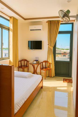 a hotel room with a bed and a television at Hostel Luxury Tây Bắc in Rạch Giá