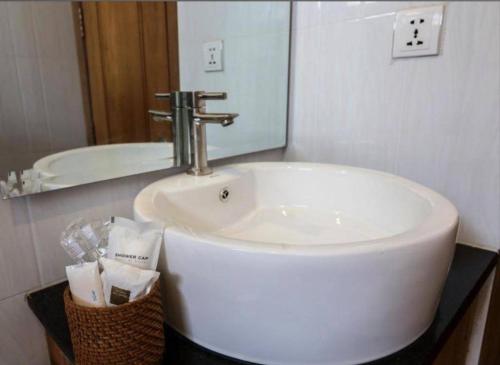 a white sink in a bathroom with a mirror at Siem Reap ABACUS Hotel in Siem Reap