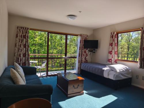a hotel room with a bed and a balcony at Aspen Lodge Motel in Hanmer Springs