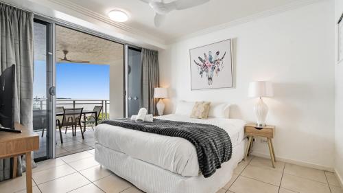 a bedroom with a bed and a balcony at Ocean View 3-Bedroom Apartment on the Esplanade in Cairns