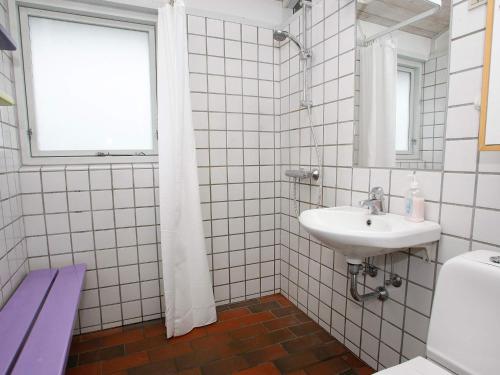 a white tiled bathroom with a sink and a window at 6 person holiday home in Hanstholm- Type1 in Hanstholm