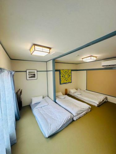 two twin beds in a room with at 時の宿 in Kawagoe