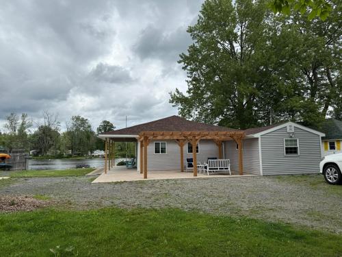 a house with a pavilion in front of a lake at Paradise Island escape Riverfront in Clay, NY in Clay