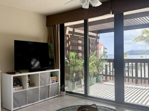 Μια τηλεόραση ή/και κέντρο ψυχαγωγίας στο Stunning Seaside Condo on Sapphire Beach with Pool