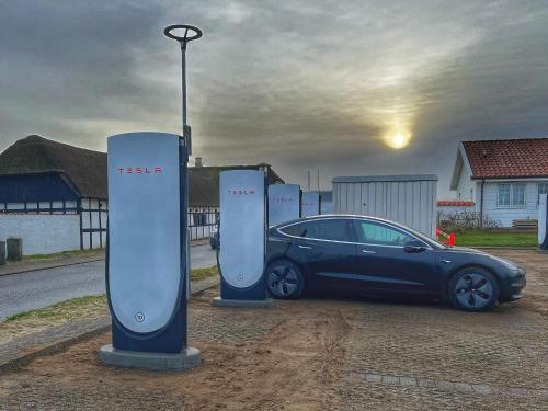 a car is parked next to two electric meters at Blokhus Feriecenter in Blokhus