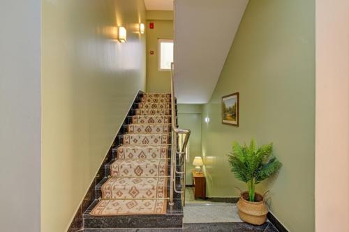 a staircase in a building with a plant at Hotel Broholi Height Inn Near Hafeezpet Railway Station in Hyderabad