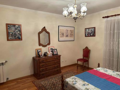 ein Schlafzimmer mit einem Bett, einer Kommode und einem Spiegel in der Unterkunft Bed and breakfast - Caminha, Portugal in Caminha