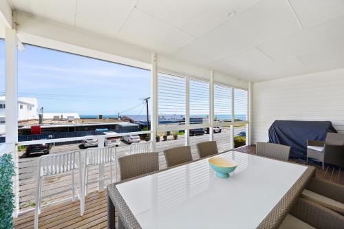 a balcony with a table and a view of a train at Bayview Escape - Aldinga Beach - C21 SouthCoast Holidays in Aldinga Beach