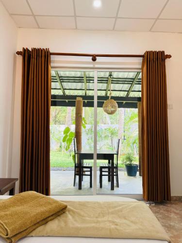 a dining room with a table and a window at Bael House Ahangama in Ahangama