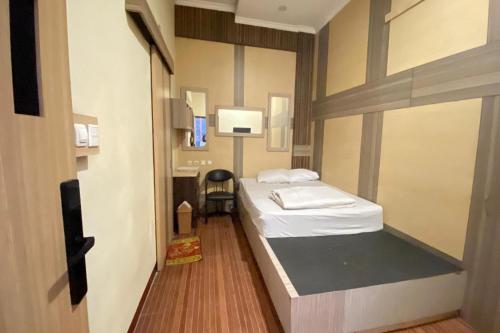 a small room with a bed and a desk at Hotel O near Maguwoharjo Stadium formerly Graha Ngaso in Seturan