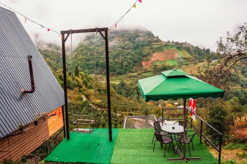 a patio with a table and a green umbrella at warm house - sunrise merisi in Merisi