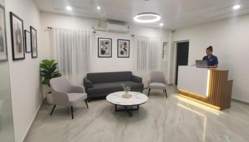 a woman standing at a podium in a living room at Hotel Broholi Height Inn Near Hafeezpet Railway Station in Hyderabad