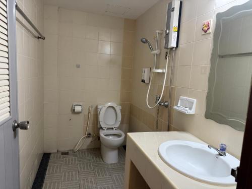 a bathroom with a toilet and a sink at Hua Lin Inn in Chiang Mai