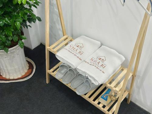 Un toallero de bambú con dos toallas y dos zapatillas. en Nhà Bi Homestay, en Xã Tân Phát