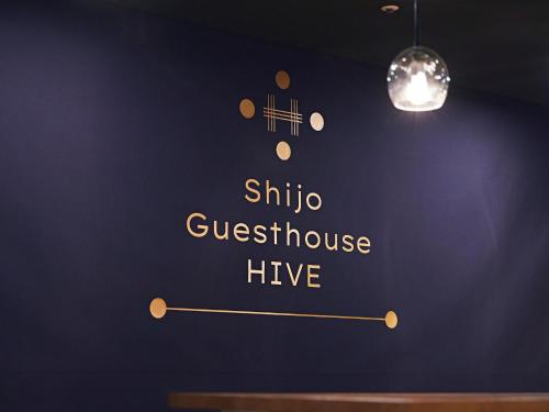 a wall with a sign that reads shinooleanbestos live at Shijo Guesthouse HIVE in Kyoto