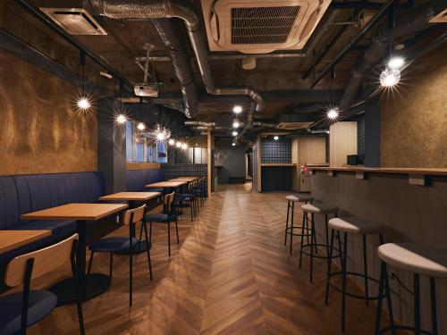 a row of tables and stools in a restaurant at Shijo Guesthouse HIVE in Kyoto