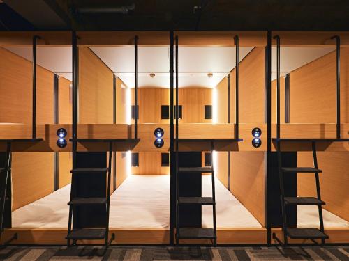 a room with bunk beds in a building at Shijo Guesthouse HIVE in Kyoto