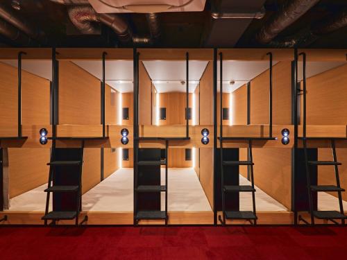 a room with a row of bunk beds at Shijo Guesthouse HIVE in Kyoto