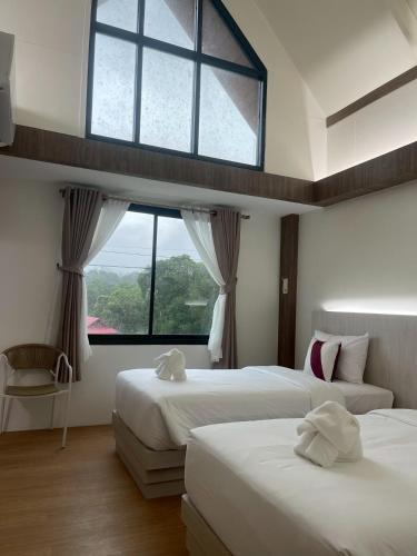 a bedroom with two beds and a large window at Salty Sand Krabi Hotel in Ban Khlong Haeng