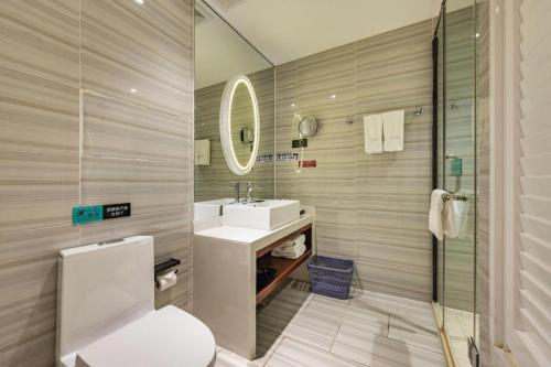 ein Badezimmer mit Waschbecken und Spiegel in der Unterkunft Xana Lite Korla Shihua Avenue Longquehe in Korla