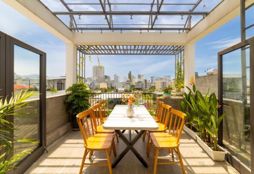 eine Terrasse mit Tisch und Stühlen auf einem Balkon in der Unterkunft Sóng homestay 4 - The spacious house - In the Prime location in Đà Nẵng